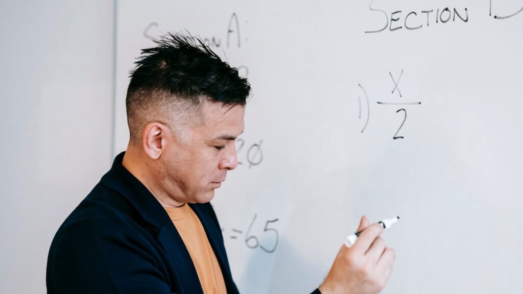 Professor explicando matemática em um quadro branco