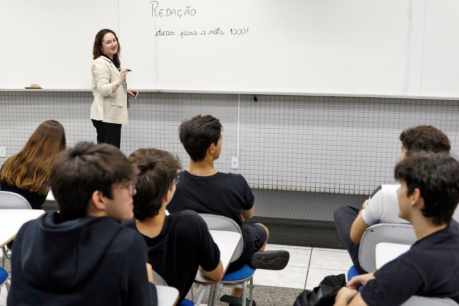 Professora Hagda Vasconcelos orienta alunos em aula de redação no colégio Galois, em Brasília, em outubro de 2024.